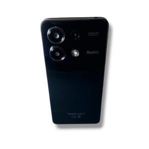 Back view of a black Redmi smartphone showing a triple-camera module and flash on the top left area