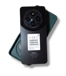 Rear view of a POCO smartphone showing a circular triple-camera array and a white barcode label on the back
