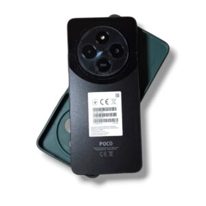Rear view of a POCO smartphone showing a circular triple-camera array and a white barcode label on the back